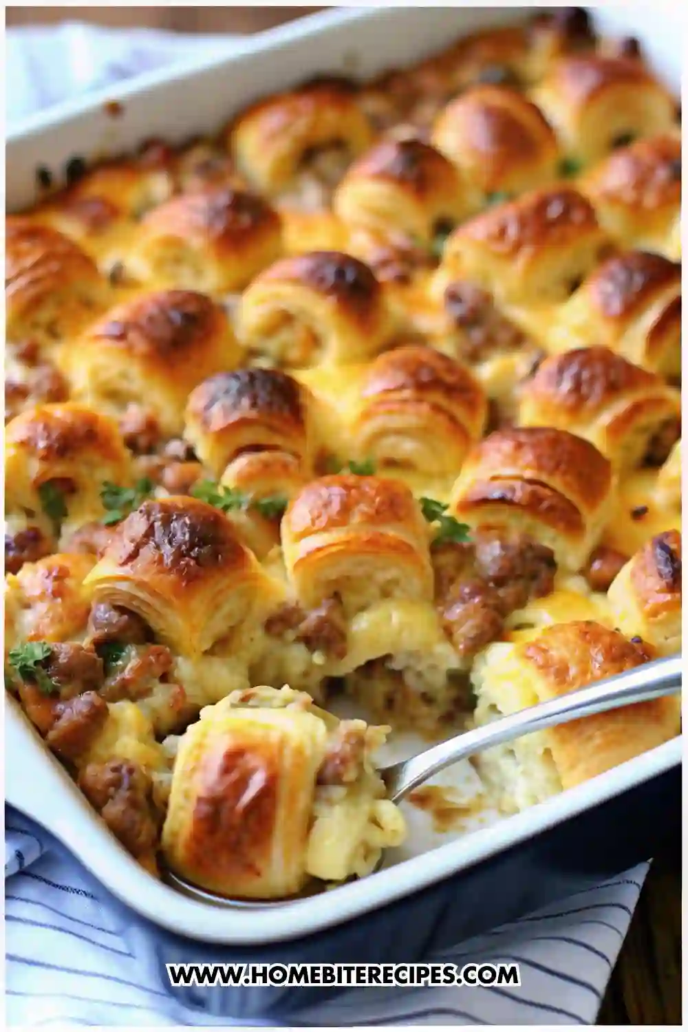 Golden-brown sausage croissant breakfast casserole baked in a dish, filled with melted cheese and flaky croissant pieces.