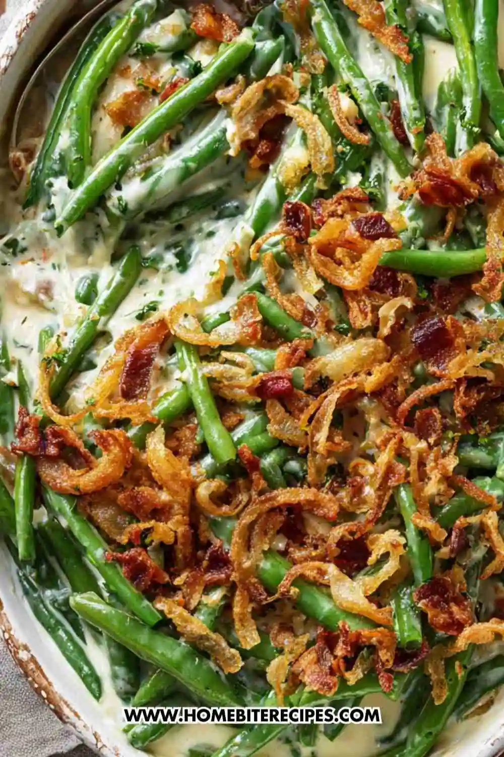 Creamy green bean casserole topped with crispy fried onions and bacon pieces.