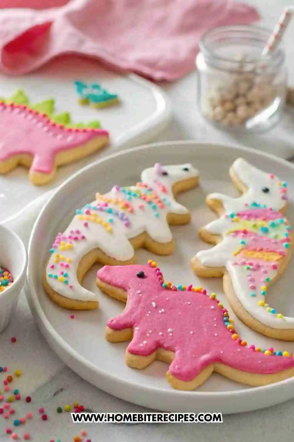 Colorful cute dinosaur sugar cookies decorated with royal icing and sprinkles on white plates.