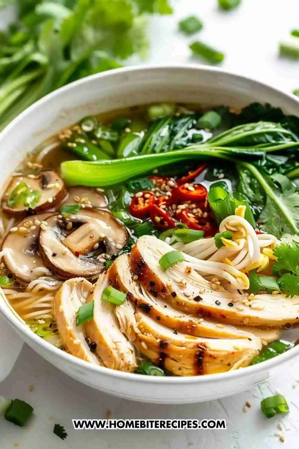 A steaming bowl of healthy chicken ramen noodle soup with sliced chicken breast, mushrooms, bok choy, chili slices, and green onions in a flavorful broth.