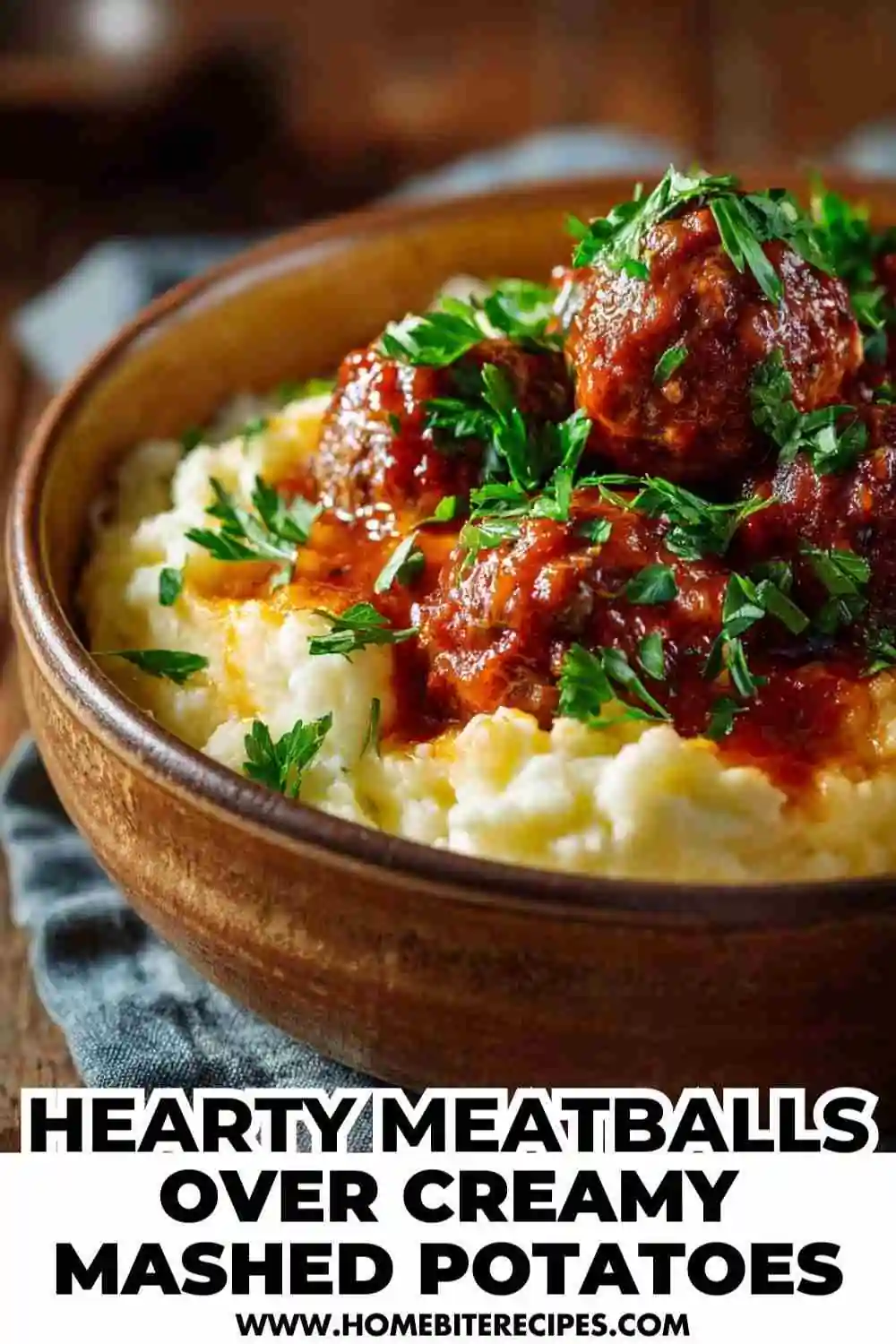 Bowl of creamy mashed potatoes topped with juicy meatballs in rich tomato sauce and fresh parsley.