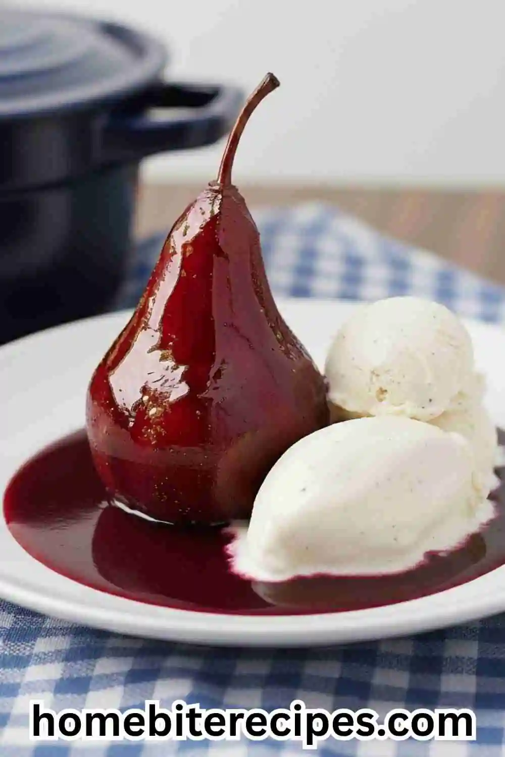 Poached Pears with Cinnamon and Pomegranate Syrup served with vanilla ice cream on a white plate, set on a checkered cloth background.