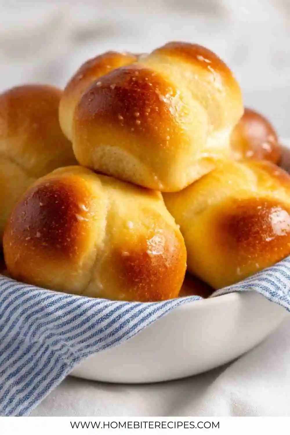 Soft and fluffy homemade dinner rolls with a golden brown crust served in a bowl.