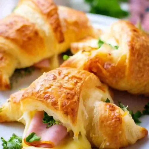 Golden, flaky croissant stuffed with warm melted cheese, ham, and fresh parsley.