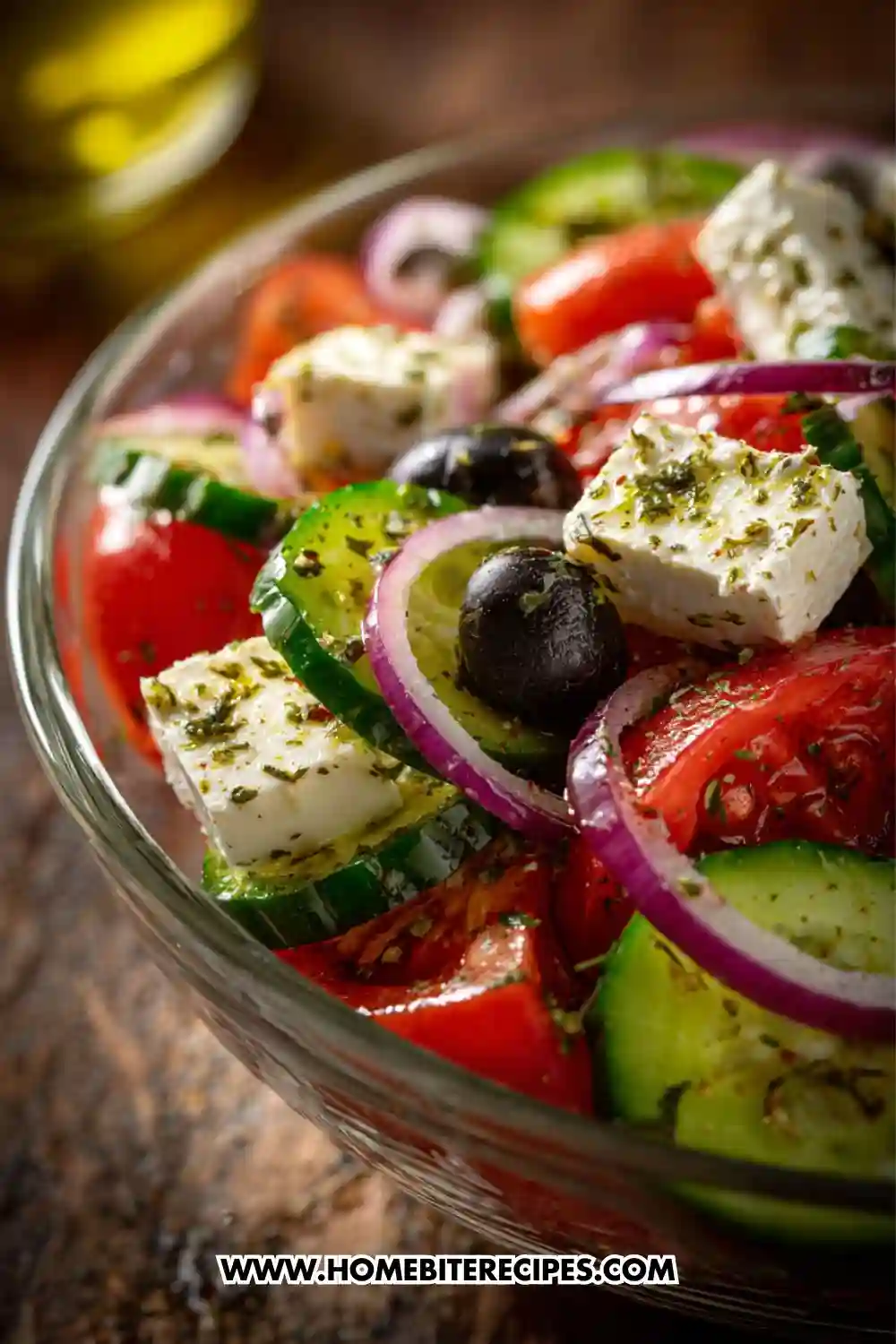 A bowl of authentic Greek salad with tomatoes, cucumbers, red onion, olives, and feta cheese tossed in herbs and olive oil.