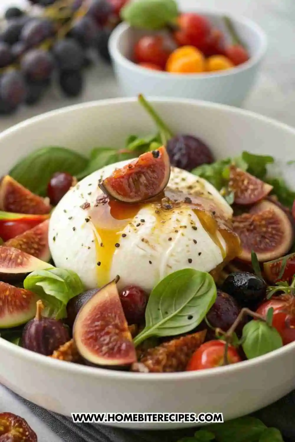 Creamy burrata salad with fresh figs, cherry tomatoes, arugula, and a honey balsamic glaze, garnished with basil and black pepper.