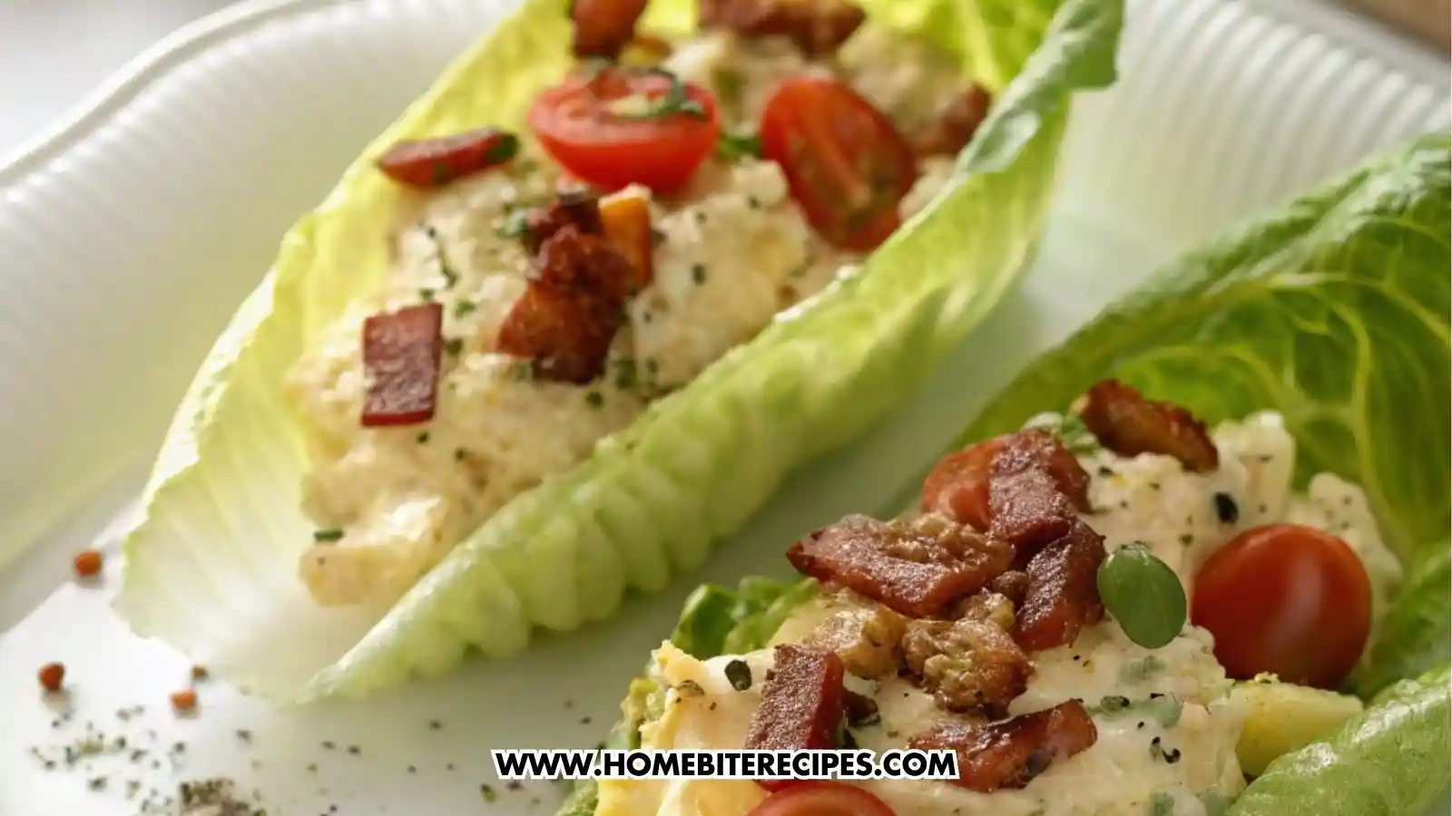 Close-up of scrambled egg lettuce cups topped with crispy beef strips, cherry tomatoes, and crumbled cheese on fresh romaine leaves.