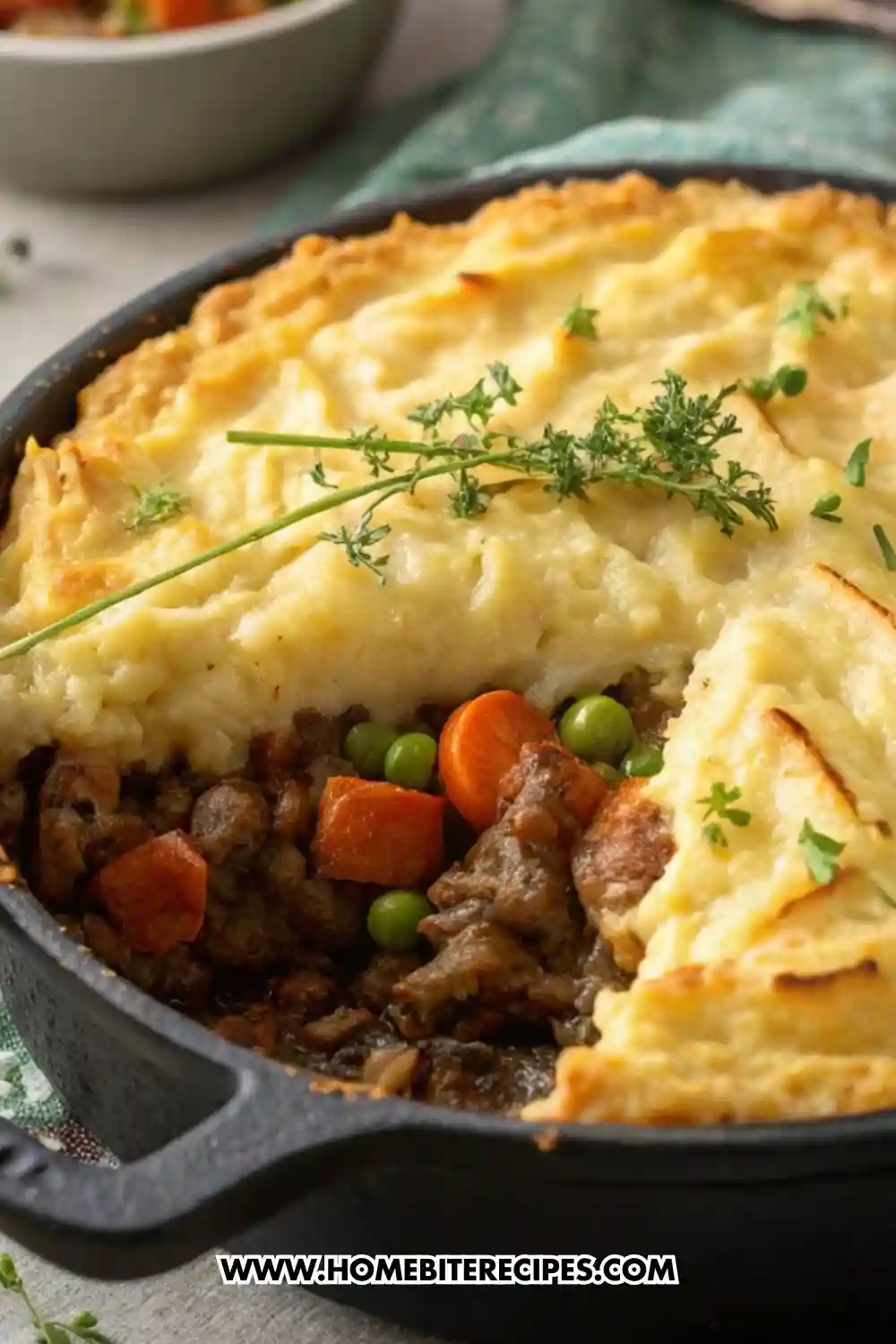 Golden-brown shepherd’s pie in a rustic casserole dish with creamy mashed potato topping and savory meat and pea filling visible from a scoop removed.