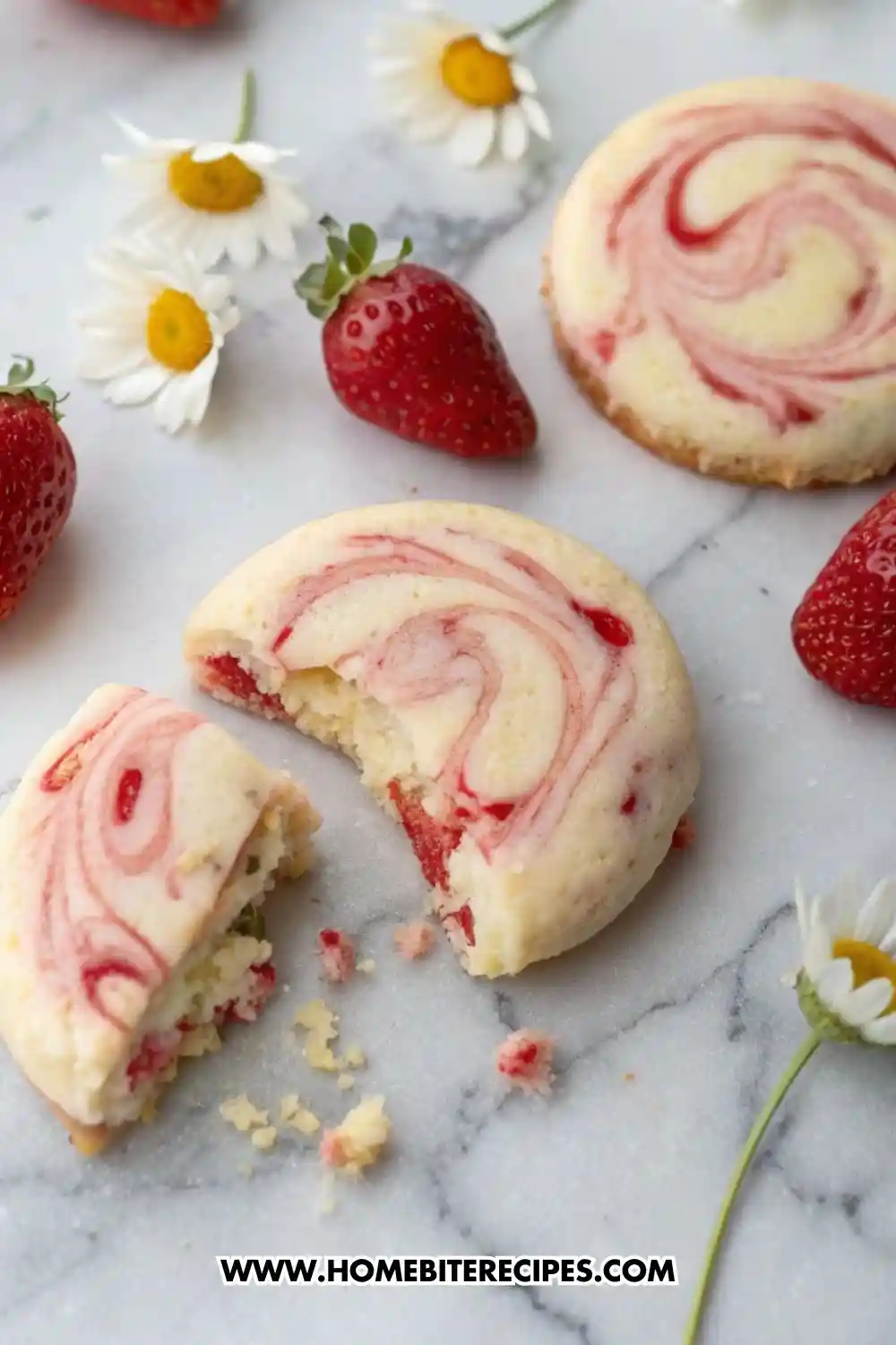 Soft gluten-free strawberry swirl cookies with red jam swirls, surrounded by fresh strawberries and daisies on a marble surface.