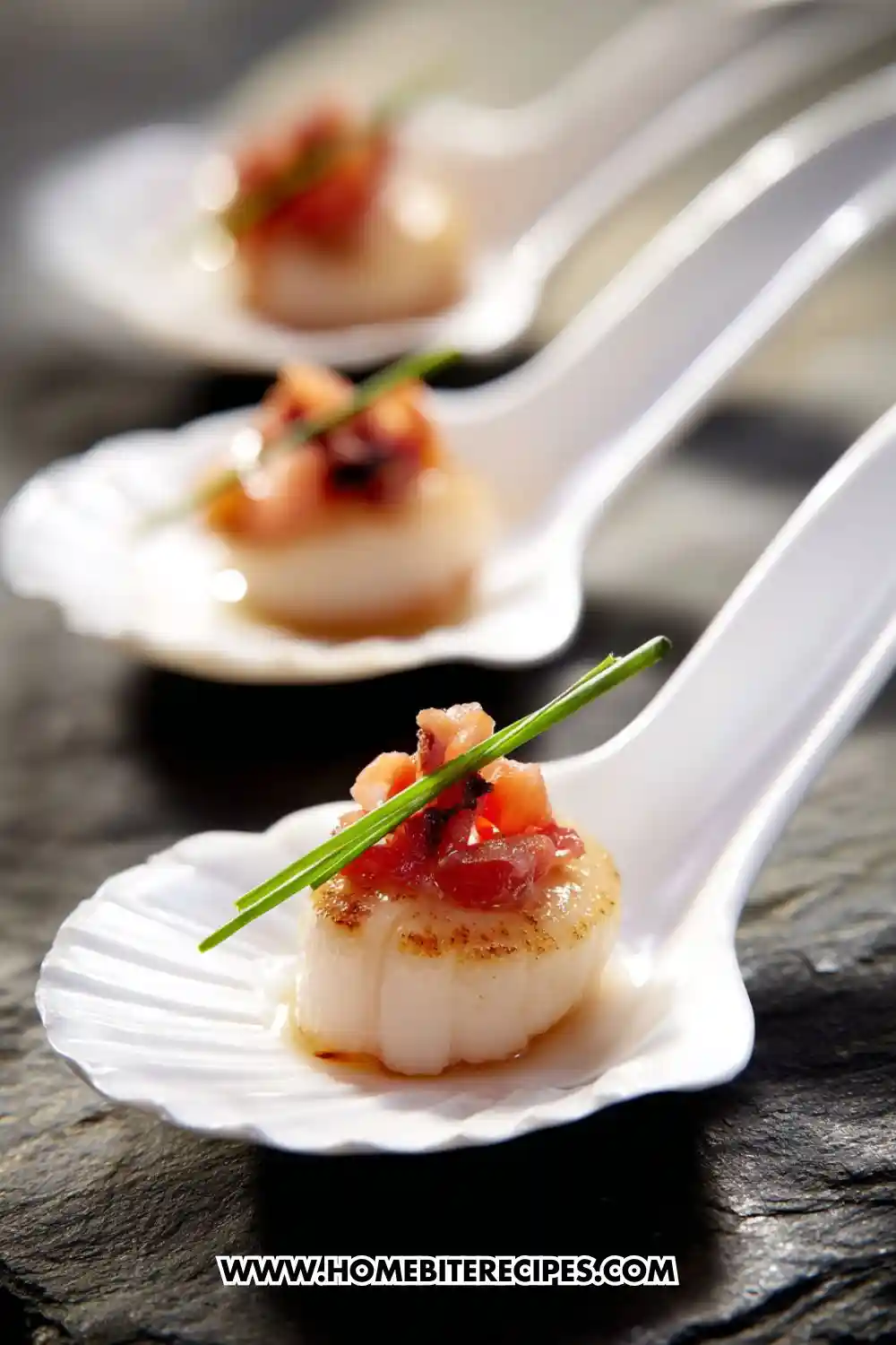 Close-up of seared scallops topped with crispy bacon and chive garnish served on white appetizer spoons, perfect elegant seafood starter.