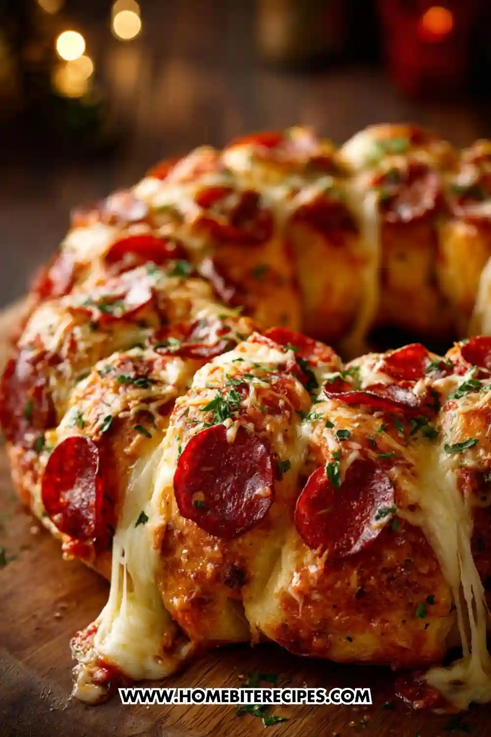 A golden pull-apart bread wreath loaded with melted mozzarella, beef pepperoni slices, garlic butter, and fresh herbs, with cheese stretching between the pieces.
