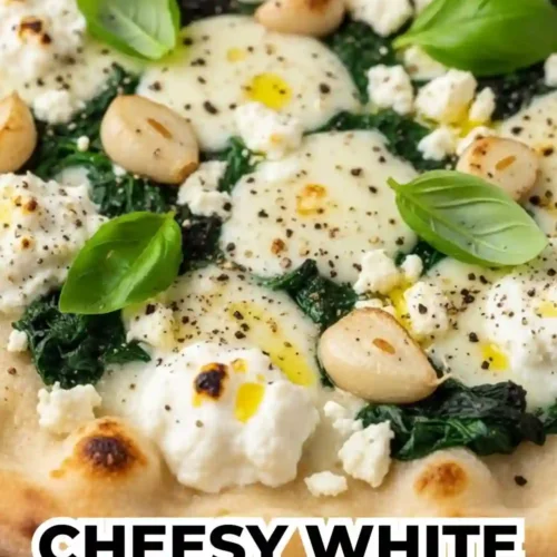 Cheesy white garlic pizza topped with spinach, melted mozzarella, creamy ricotta, roasted garlic cloves, and fresh basil on a golden pizza crust.