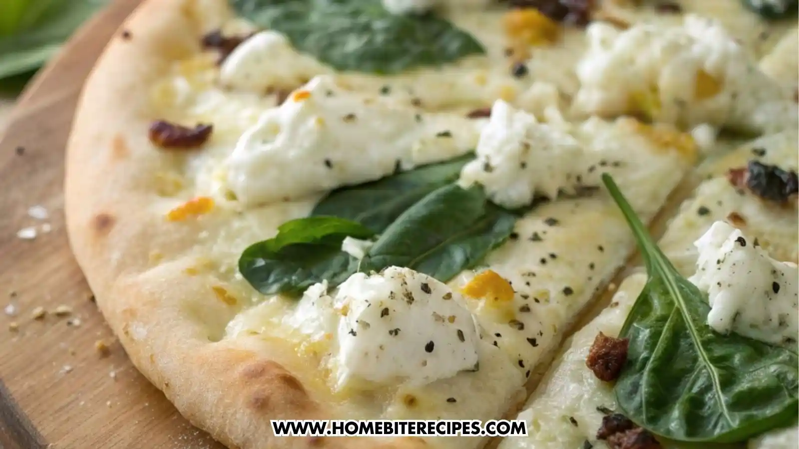 Cheesy white garlic pizza topped with spinach, melted mozzarella, creamy ricotta, roasted garlic cloves, and fresh basil on a golden pizza crust.