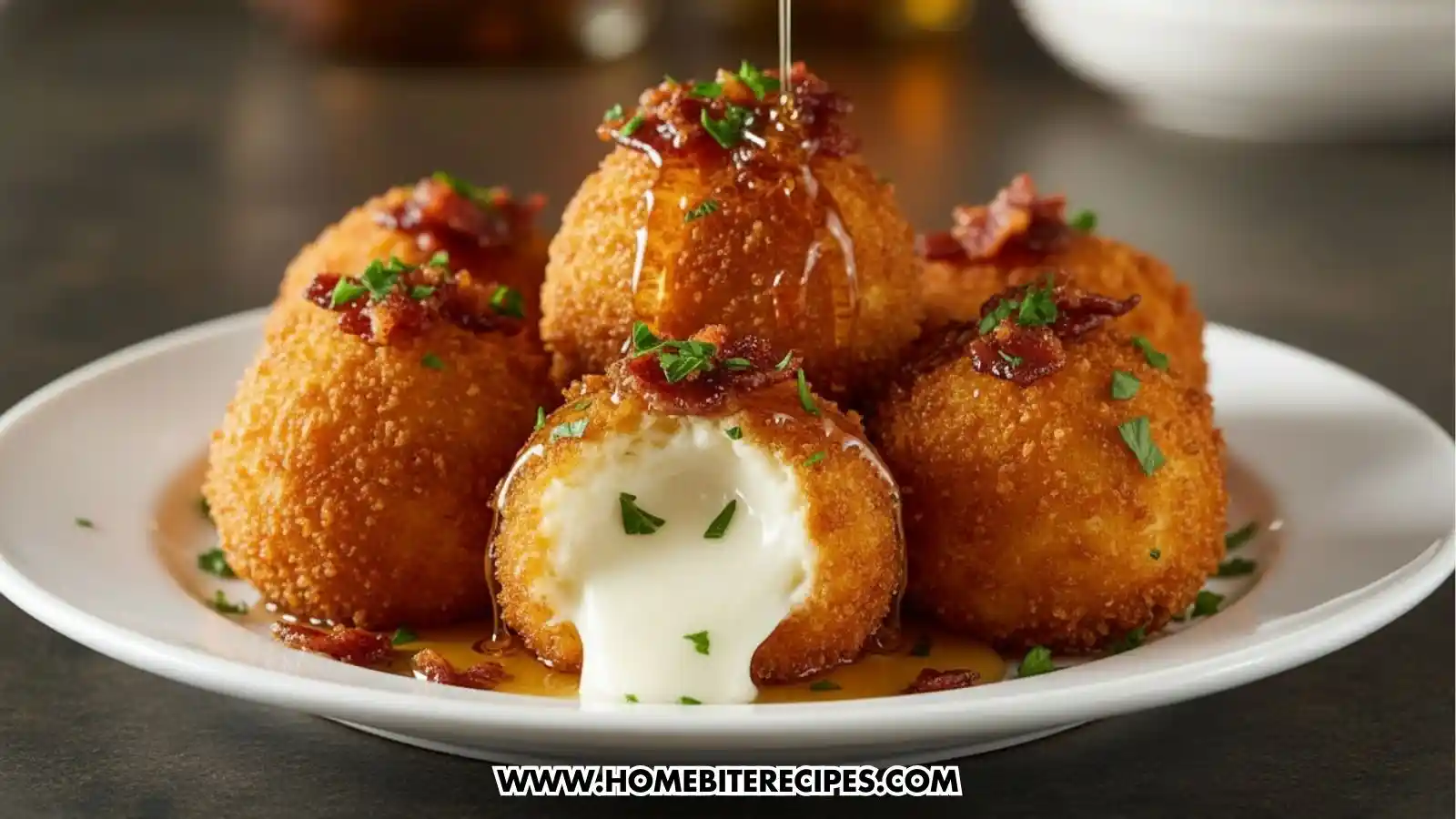 Close-up of crispy buffalo chicken mozzarella bombs filled with melted cheese, topped with bacon and herbs, dripping with sauce.
