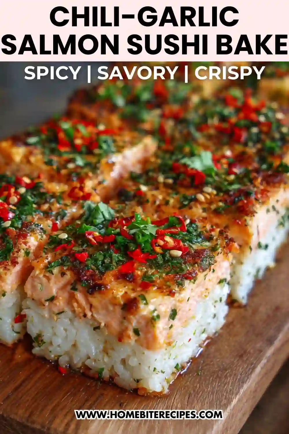 Baked salmon sushi squares topped with chili, garlic, herbs, and sesame seeds on a wooden board.