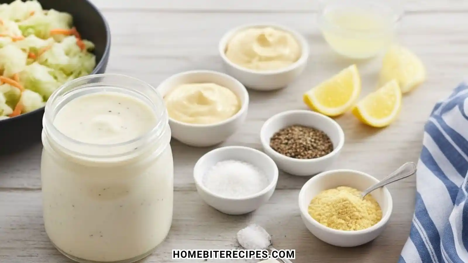 A flat-lay arrangement of fresh ingredients for Classic Homemade Coleslaw Dressing including mayonnaise, lemon wedges, salt, pepper, and celery seed.