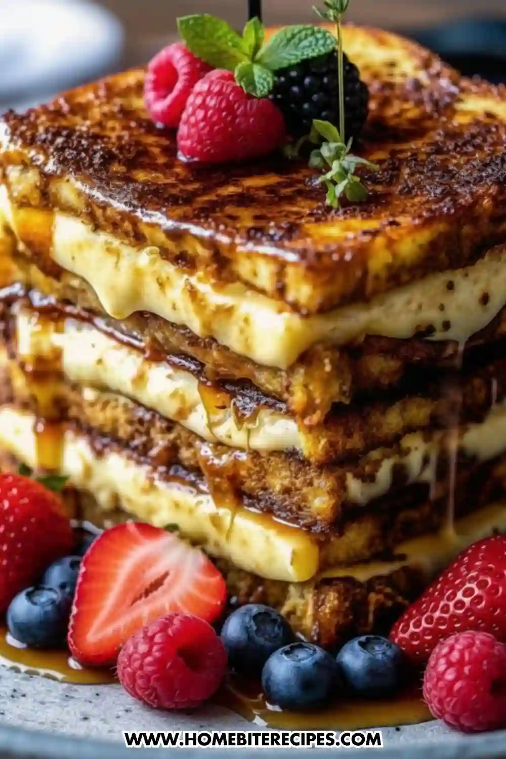 Stacked crème brûlée French toast made with thick brioche slices, creamy custard filling, caramelized sugar topping, and maple syrup dripping down the sides.