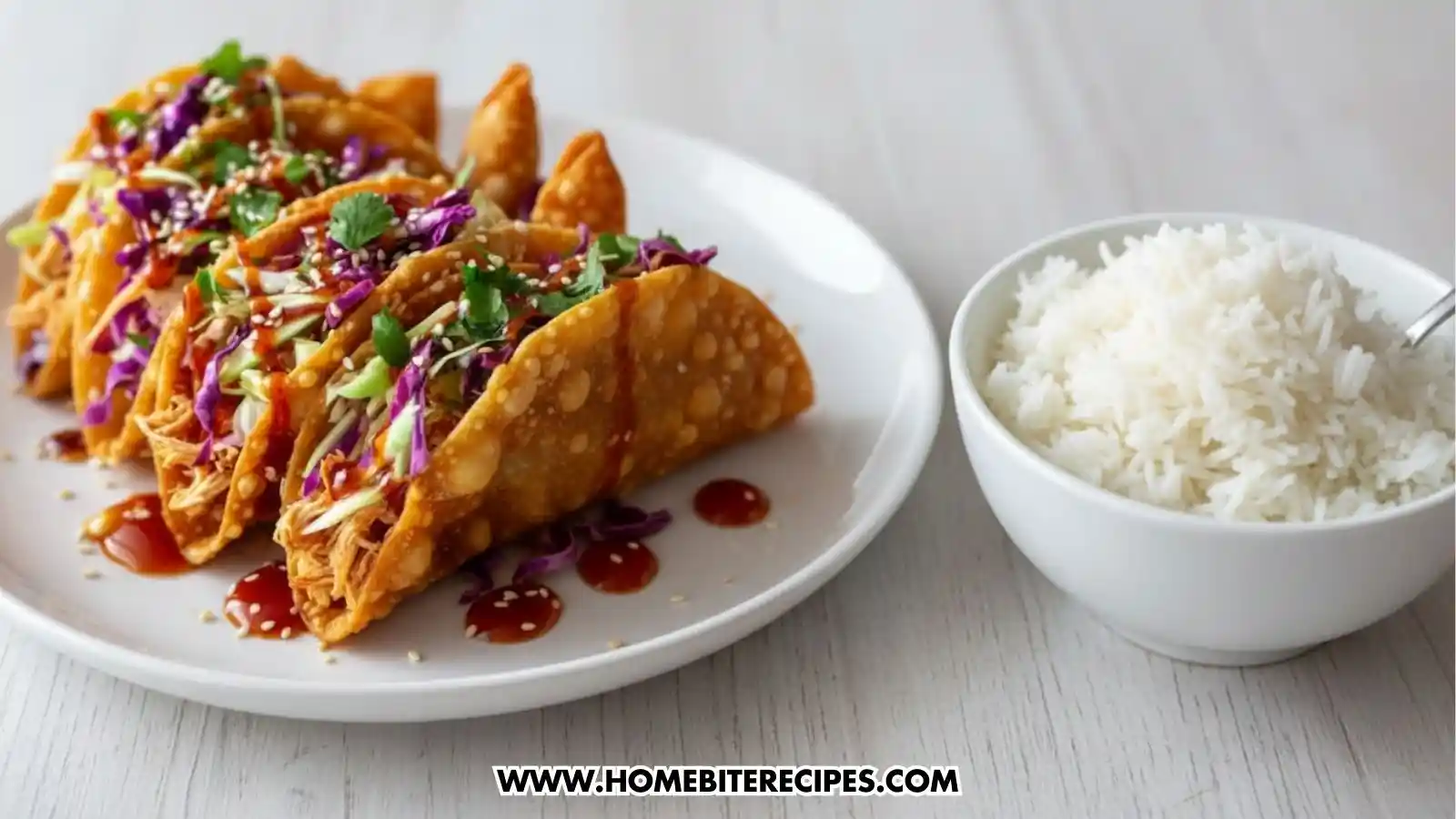 Crispy Asian Chicken Tacos filled with shredded chicken, colorful cabbage slaw, cilantro, sesame seeds, and sweet chili sauce served with a bowl of jasmine rice