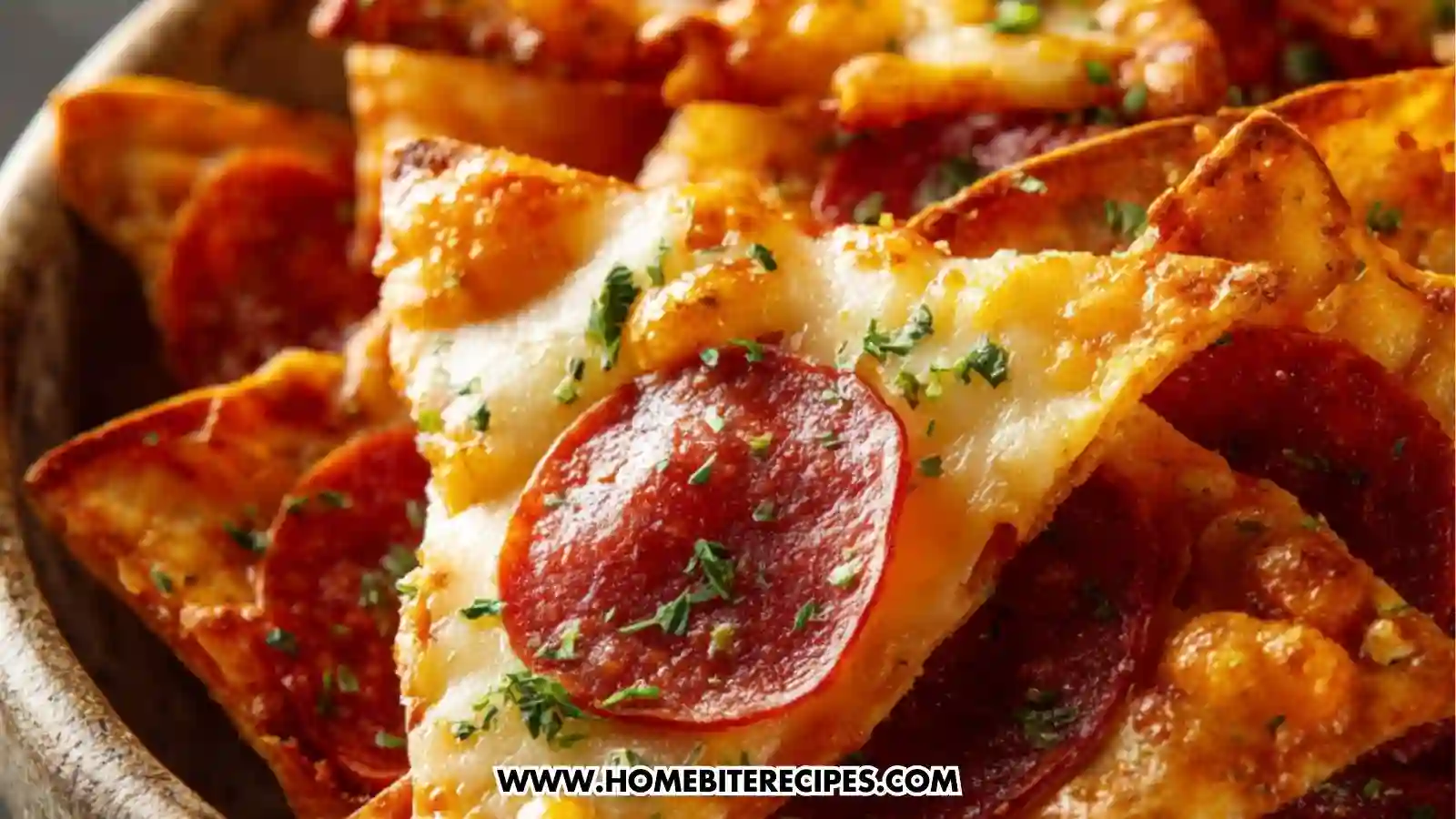 Close-up of crispy baked tortilla chips topped with melted cheese, beef pepperoni slices, herbs, and seasonings, served in a rustic bowl.