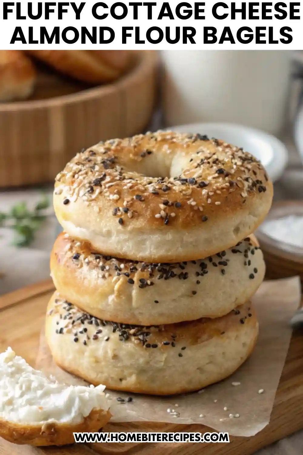 Stack of fluffy homemade cottage cheese almond flour bagels topped with everything seasoning, served on a wooden board.