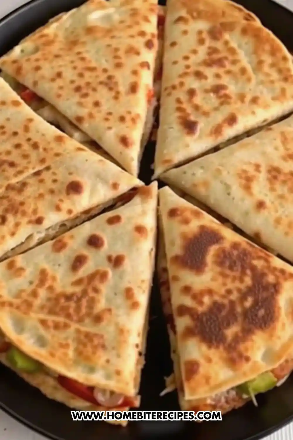 Crispy chicken and vegetable quesadilla wedges cooked until golden brown and sliced into triangles on a black pan.