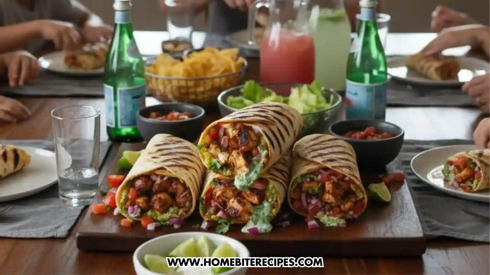 A close-up view of a platter of grilled chicken wraps showing detailed cross-sections of the filling, set on a dining table alongside sparkling water bottles, bowls of salsa, tortilla chips, and fresh lime wedges.