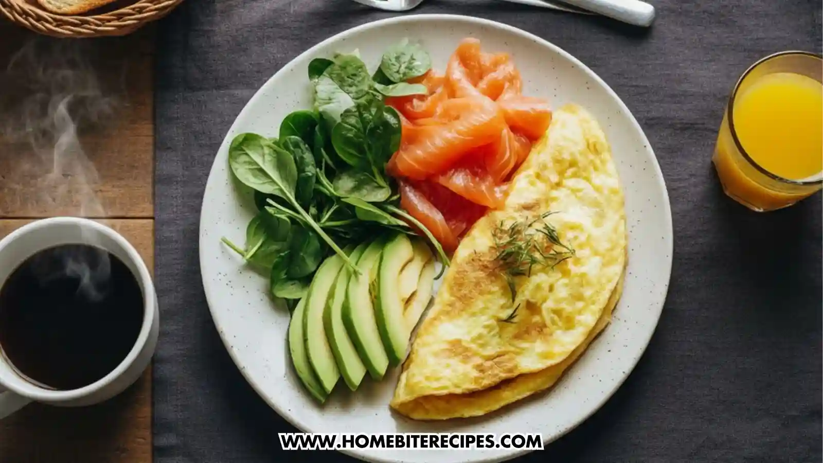 Healthy Smoked Salmon Omelet served with sliced avocado, and fresh spinach on a ceramic plate, topped with dill and prepared as a low-carb breakfast alongside coffee and orange juice.