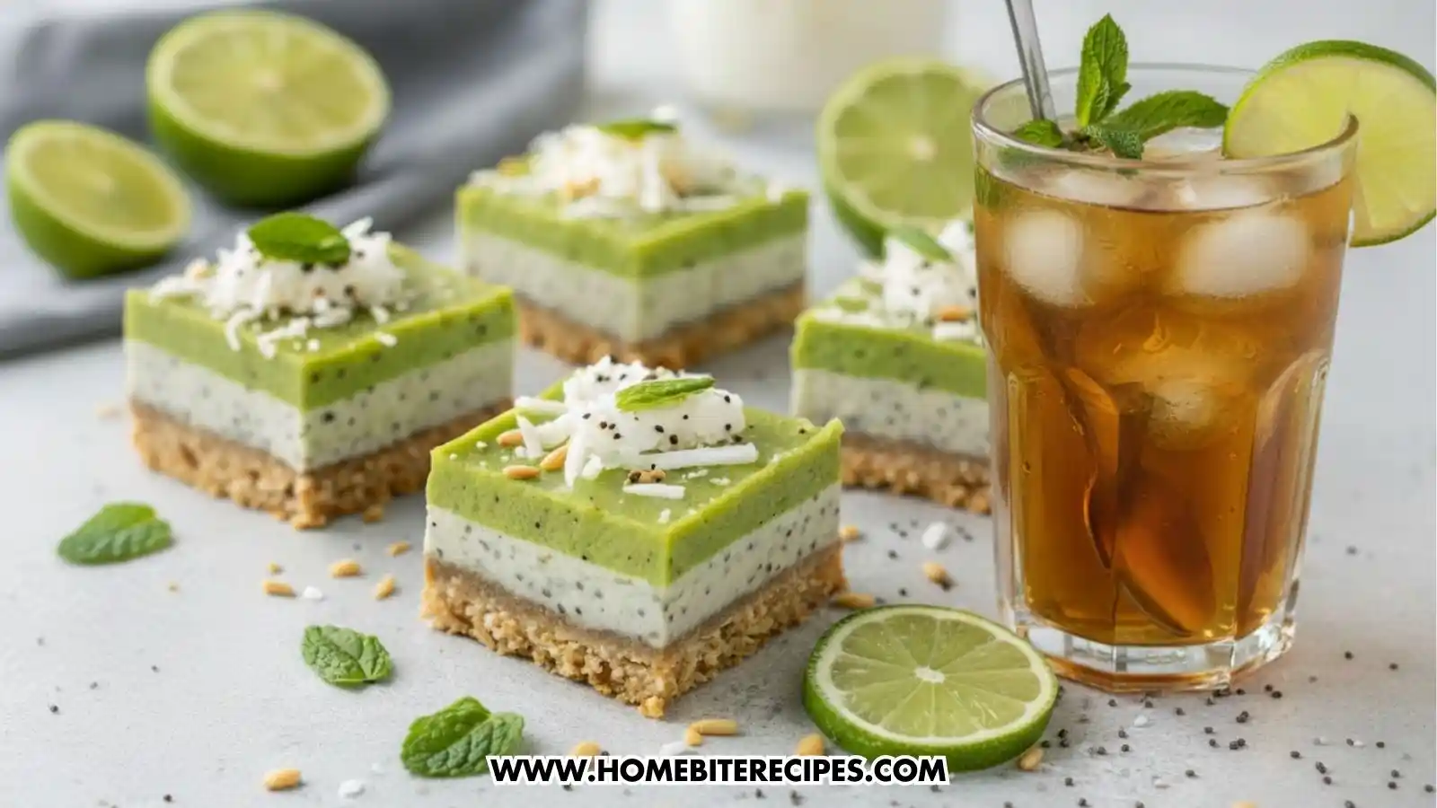 Close-up of layered no-bake chia pudding bars with a nutty date crust, creamy coconut-lime chia filling, and a vibrant green lime layer topped with shredded coconut, mint, and toasted seeds, served with a glass of mint-infused iced tea