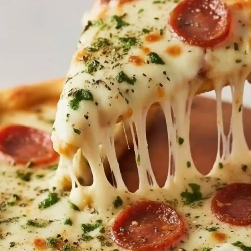 Slice of homemade pepperoni pizza with melted mozzarella cheese stretch and Italian herbs on a golden crust.