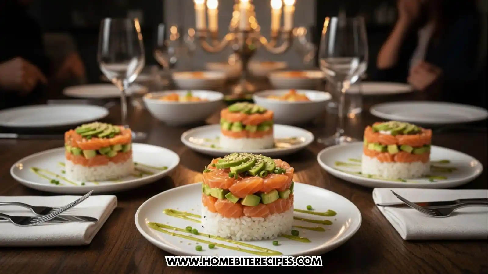 A sophisticated dinner table set for multiple guests, featuring several completed salmon and avocado sushi towers as the main course. Each tower is presented on a white plate with decorative green sauce drizzles. The background is dimly lit with a glowing candle chandelier and wine glasses, creating an elegant and warm dining atmosphere.