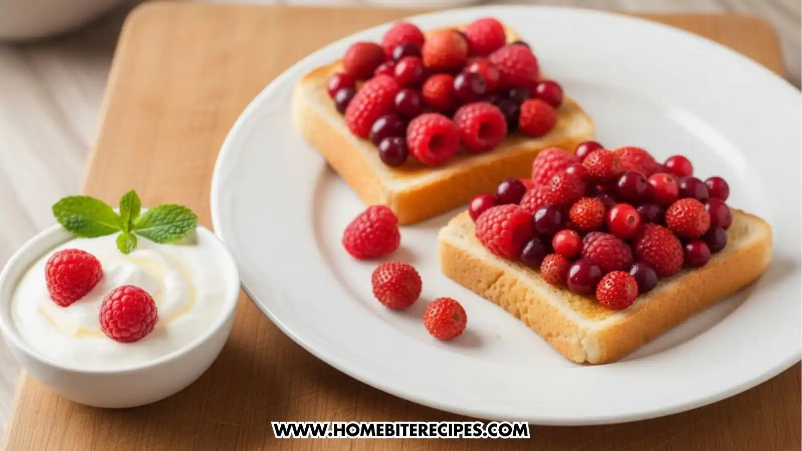 Two slices of Mixed Berry Toast topped with a thick layer of raspberries, cranberries, and wild strawberries, served on a white plate with a side bowl of Greek yogurt garnished with fresh raspberries and mint.