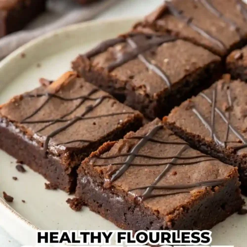 Fudgy flourless Greek yogurt brownies cut into squares on a plate, drizzled with dark chocolate on top, showing their rich and moist texture.