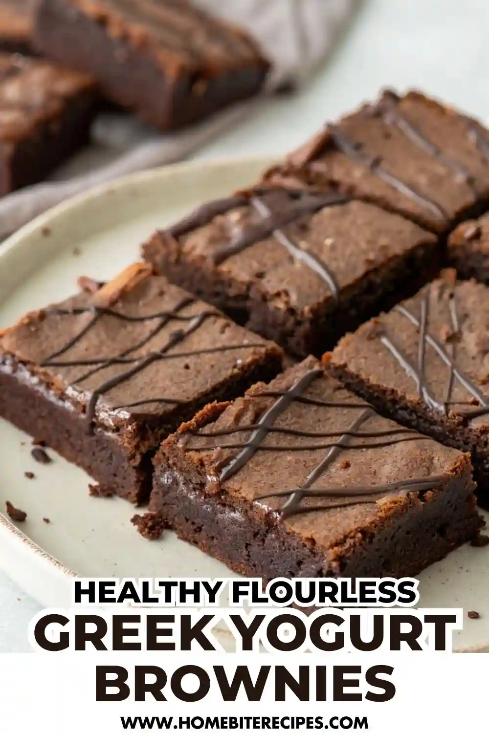 Fudgy flourless Greek yogurt brownies cut into squares on a plate, drizzled with dark chocolate on top, showing their rich and moist texture.