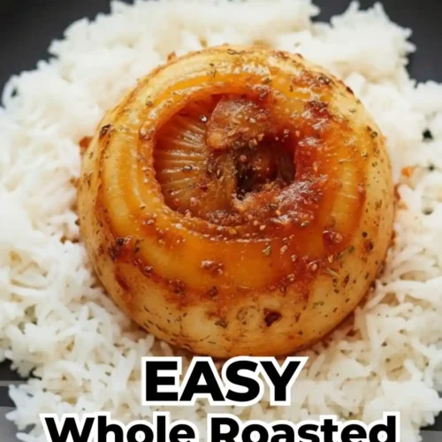 whole, tender roasted onion with a caramelized golden-brown glaze and savory herbs, served prominently in the center of a bed of fluffy white basmati rice on a matte black plate.